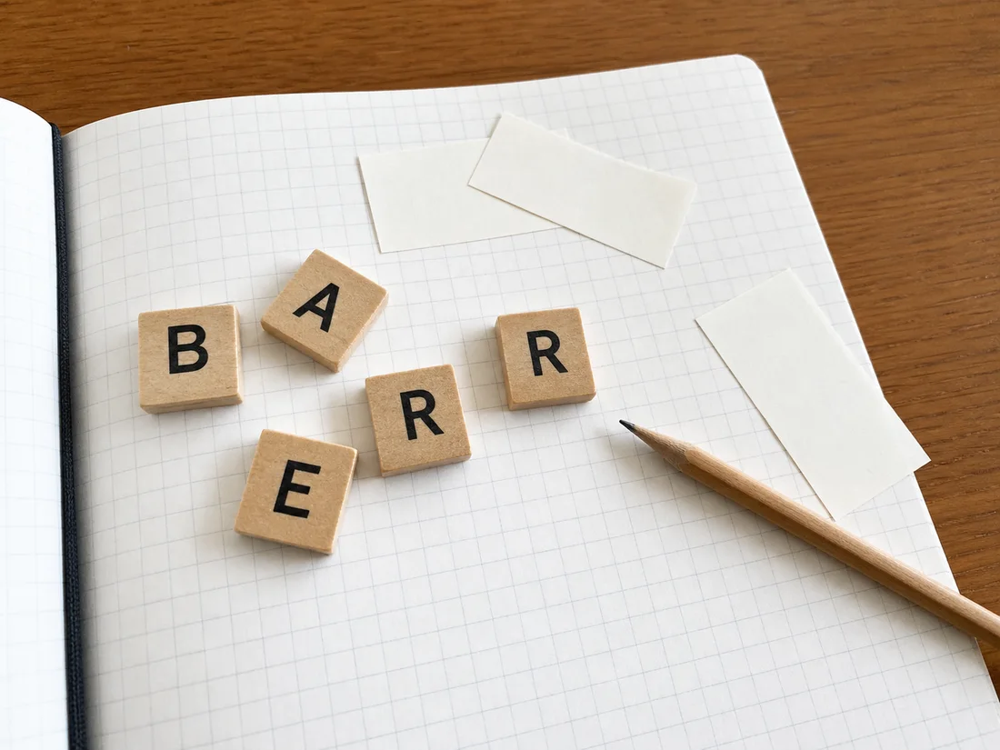 Lettres B A R R E rearrangees sur un carnet quadrille