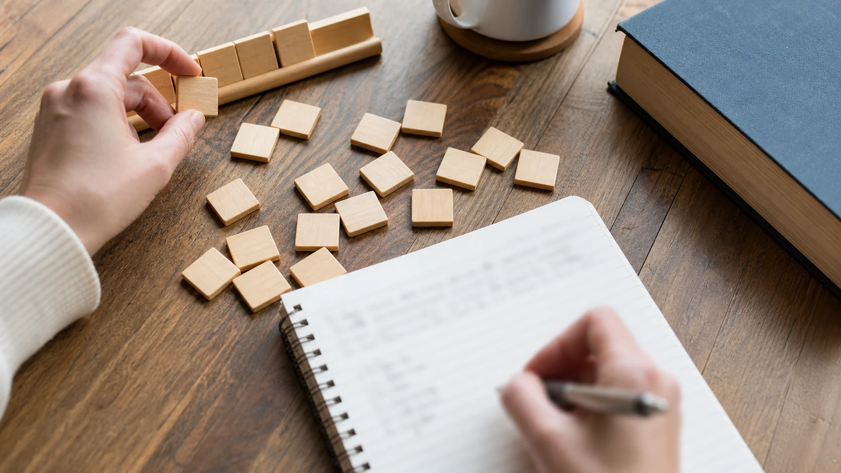 Joueur trie des tuiles de lettres en préparant des mots sur un carnet